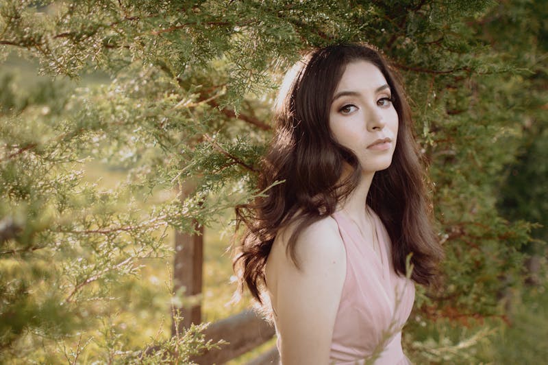 Portrait extérieur d'une femme en robe rose entourée de verdure à San Cristóbal de las Casas