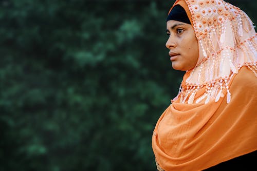 Женщина в оранжевом хиджабе на селективной фотографии