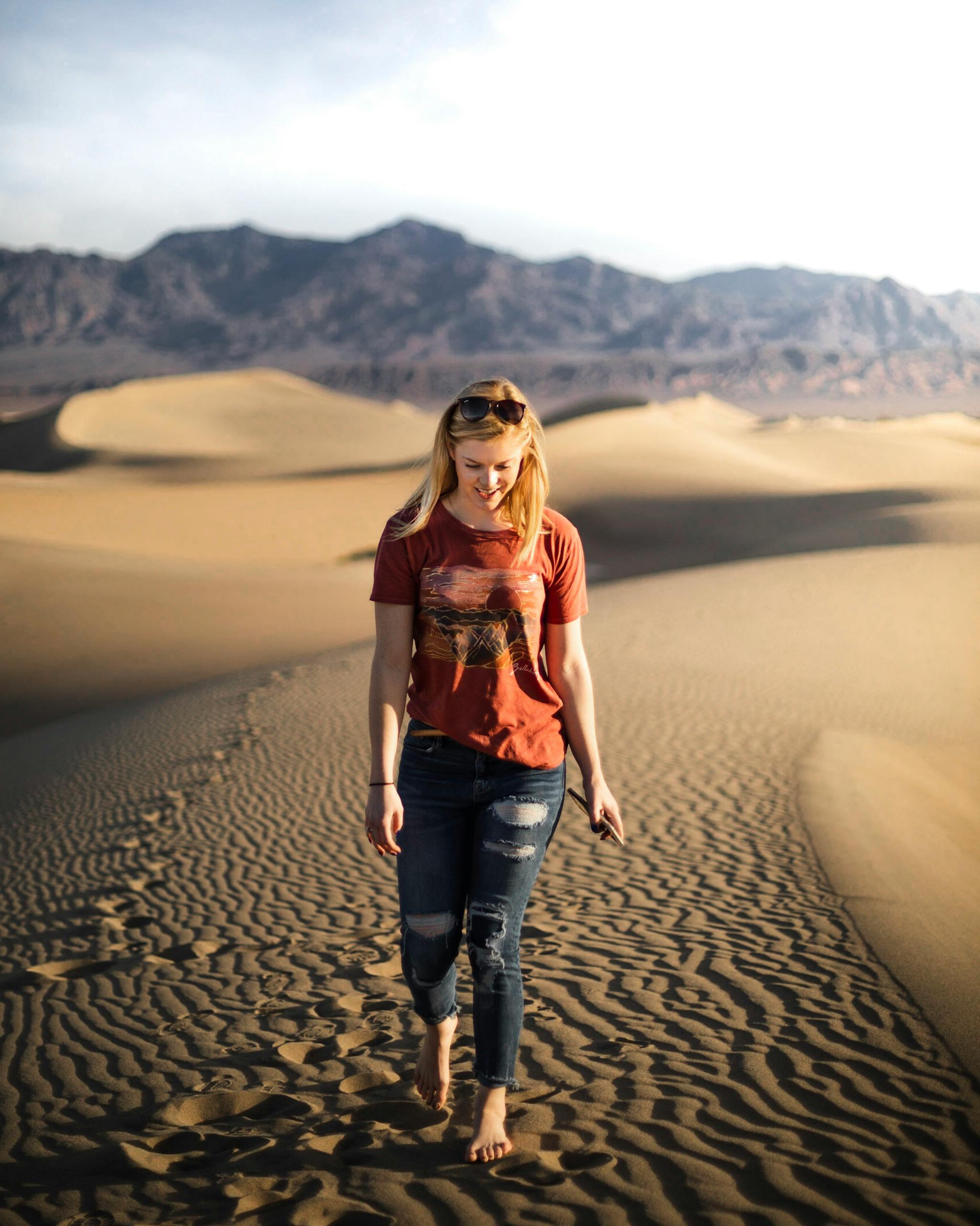 woman walking on sand dunes