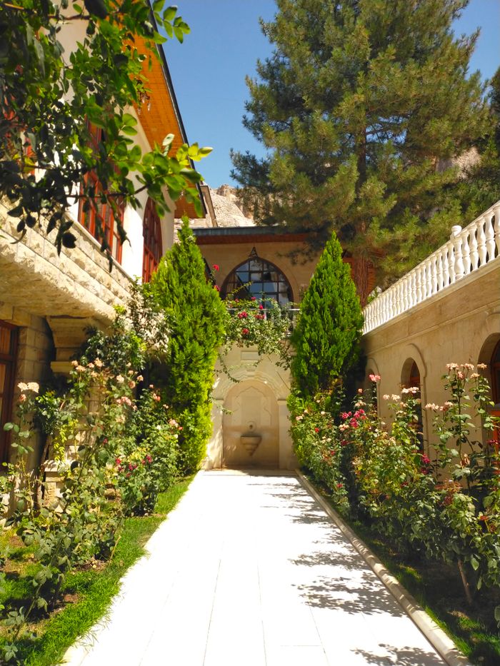 Garden path between old stone buildings — photo by Suheda Cansiz on Pexels