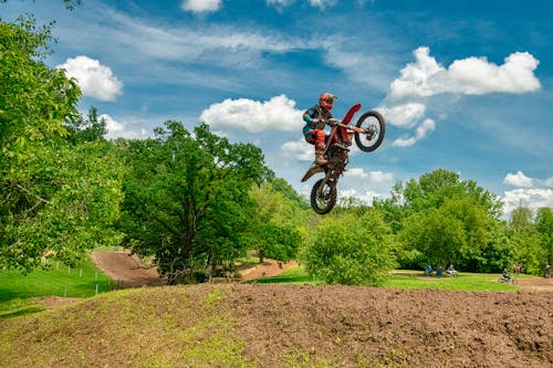 Man Riding on Black and Red Motocross Dirt Bike