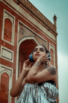 在新德里，一名纹身女子穿着抹胸，戴着耳机在户外欣赏音乐