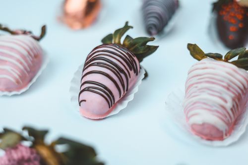 Free A close-up of assorted pink and chocolate-dipped strawberries showcasing intricate designs, perfect for weddings and celebrations. Stock Photo