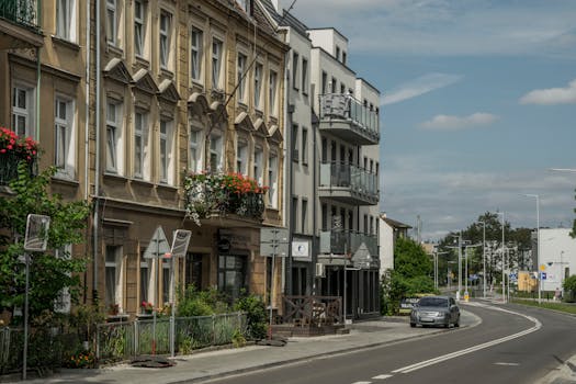 Street view of residential buildings and a car in Wrocław, showcasing city life.
