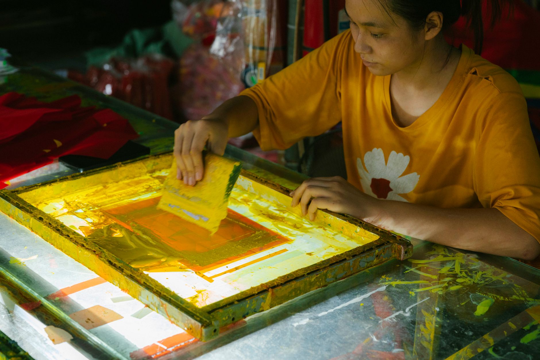 Atelier de marquage textile appliquant un motif coloré, illustrant la personnalisation avant transfert DTF