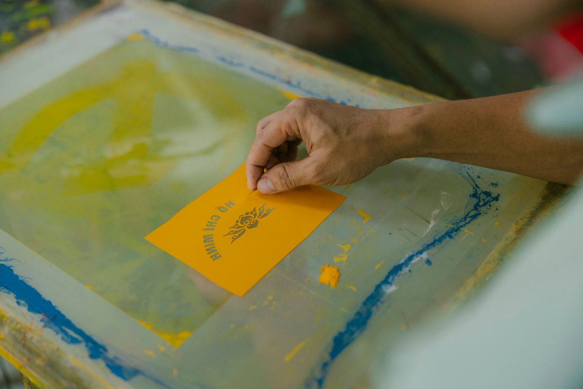 Hand screen printing a design onto paper