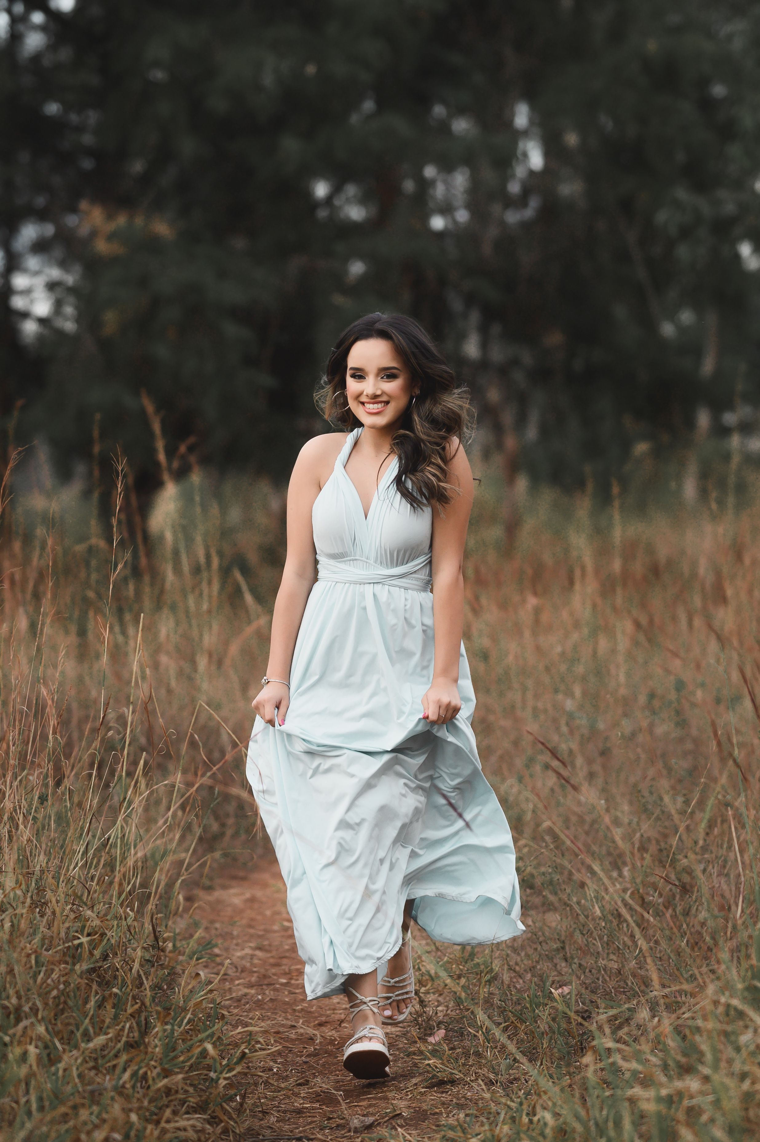 A woman in a long dress walking through a field · Free Stock Photo