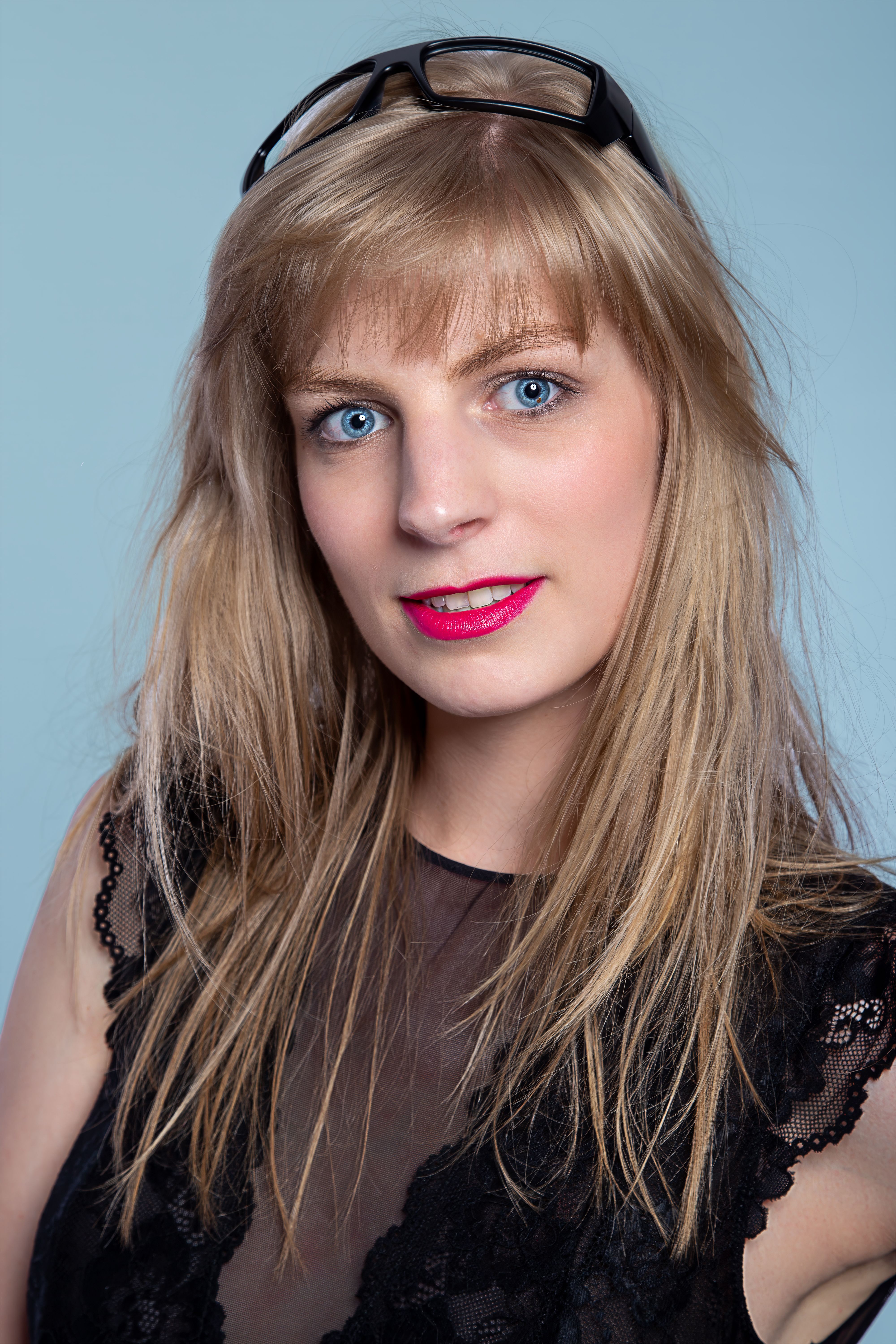 Portrait of a young woman with blonde hair, wearing black lace. Elegant and fashionable look.
