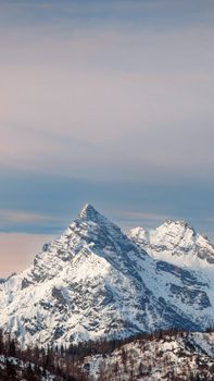 Scenic view of a snow-covered mountain peak with a clear sky, perfect for winter travel enthusiasts.