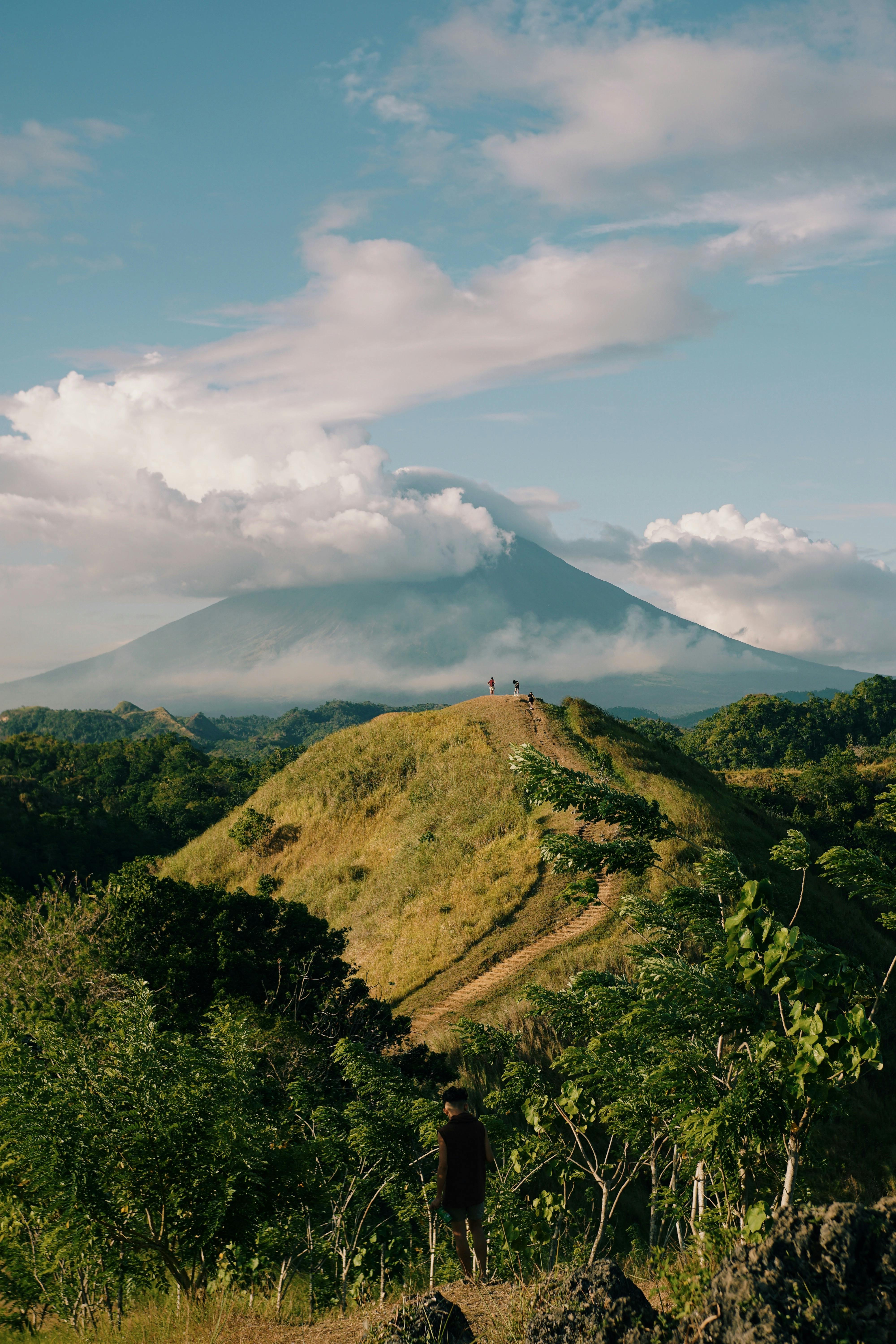 a person standing on a hill overlooking a volcano