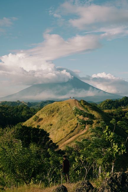 Idyllic landscape of a mountain and lush hills under a bright blue sky, perfect for travel enthusiasts.