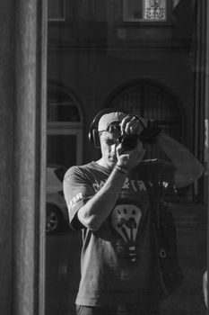 Monochrome reflection of a photographer capturing the moment outdoors.