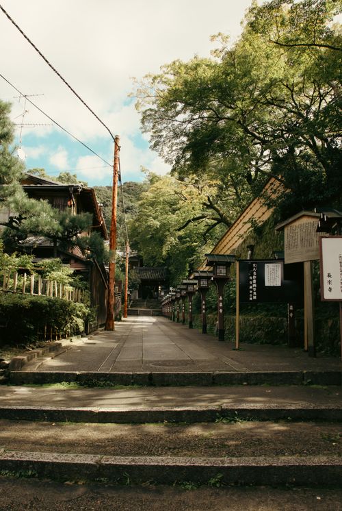 Free Picturesque pathway lined with traditional Japanese buildings and lush greenery. Stock Photo