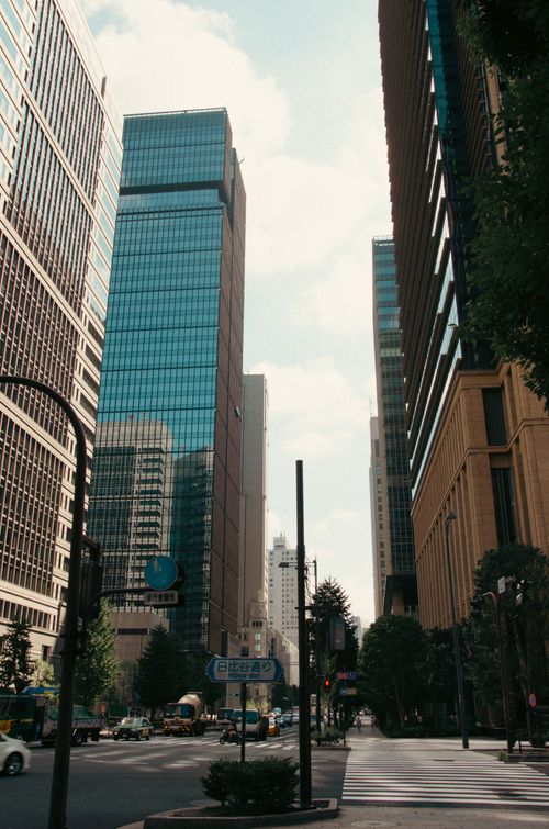 Free Dynamic city street view with towering skyscrapers and modern architecture under a bright sky. Stock Photo