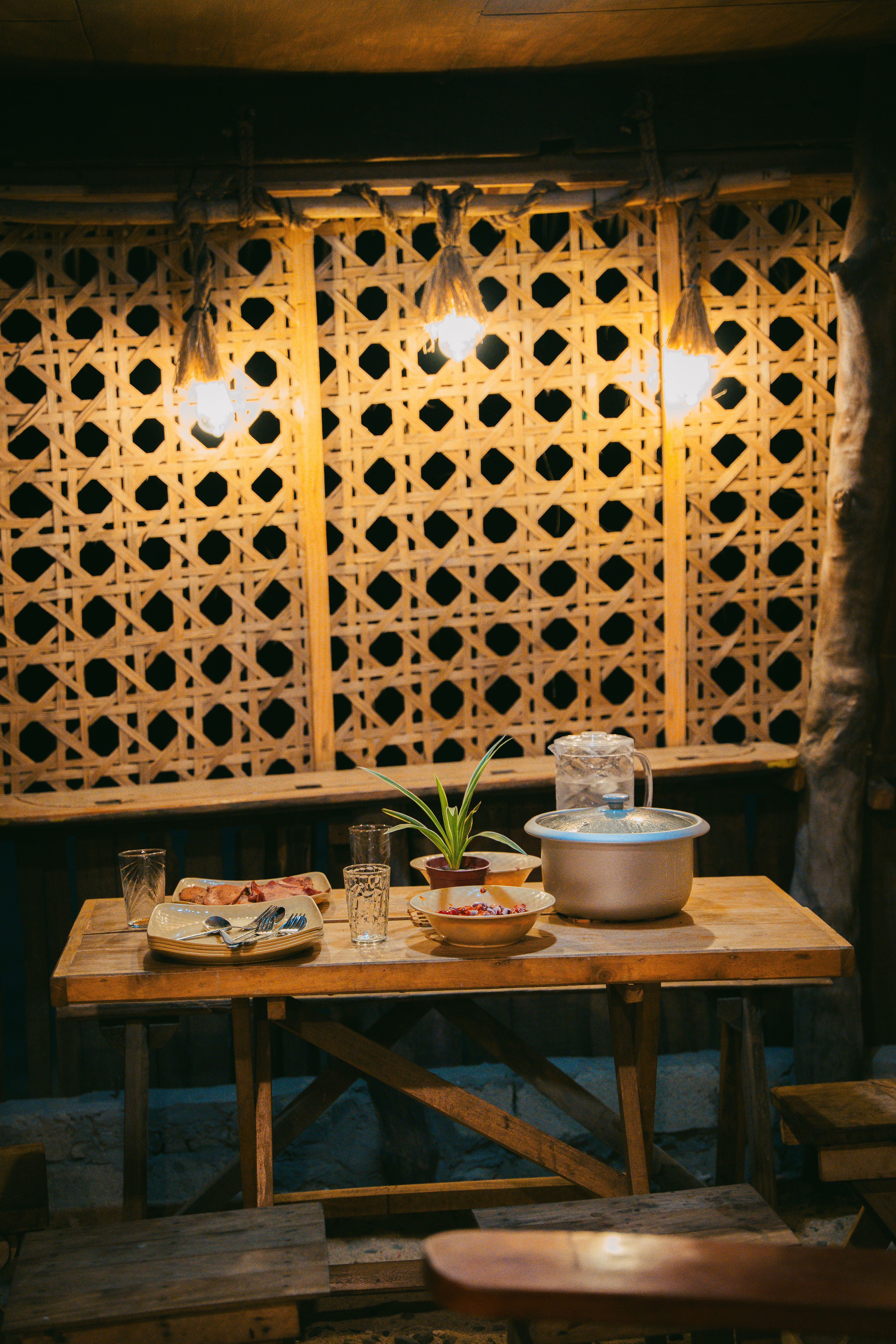 A wooden dining table with warm lighting in a rustic interior showcasing traditional decor.