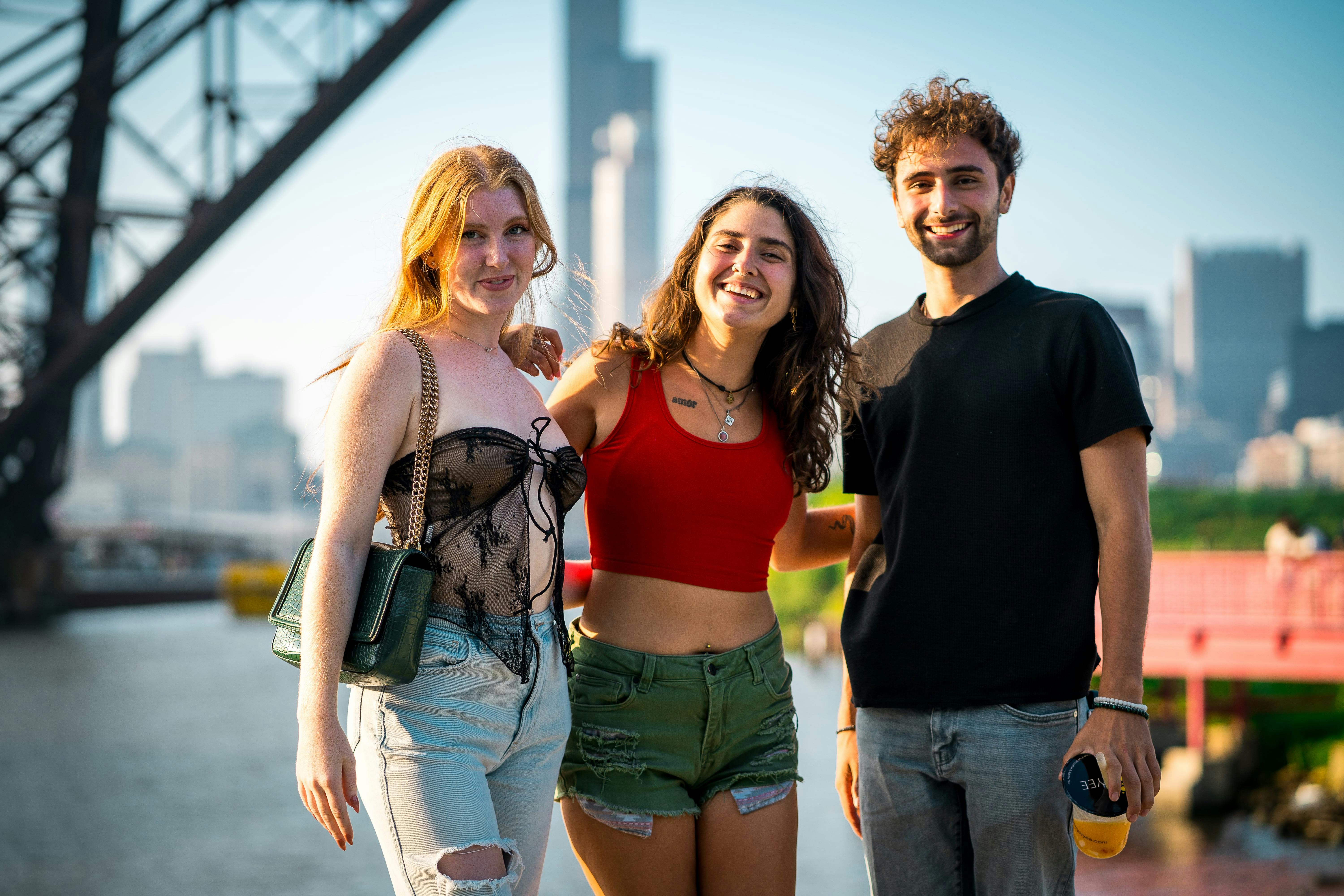 three people standing in front of a bridge