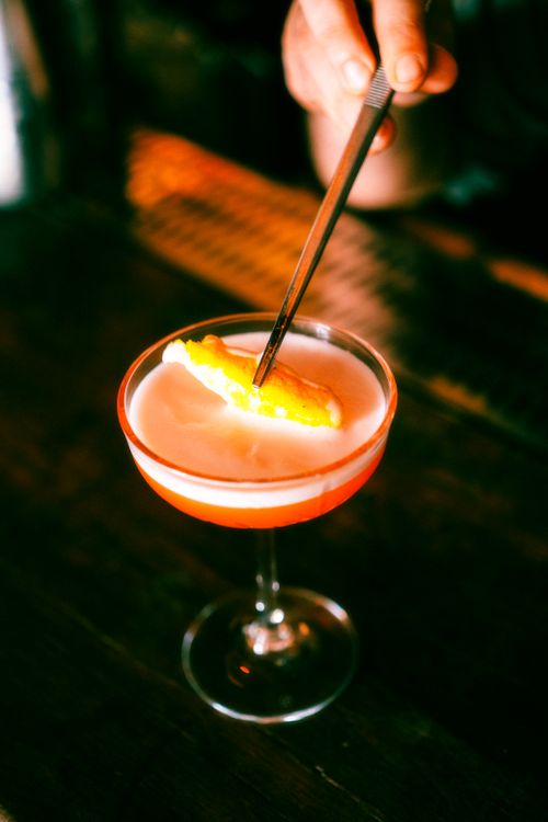 Free A tantalizing cocktail garnished with a citrus slice in a chic glass, perfectly captured in low light. Stock Photo