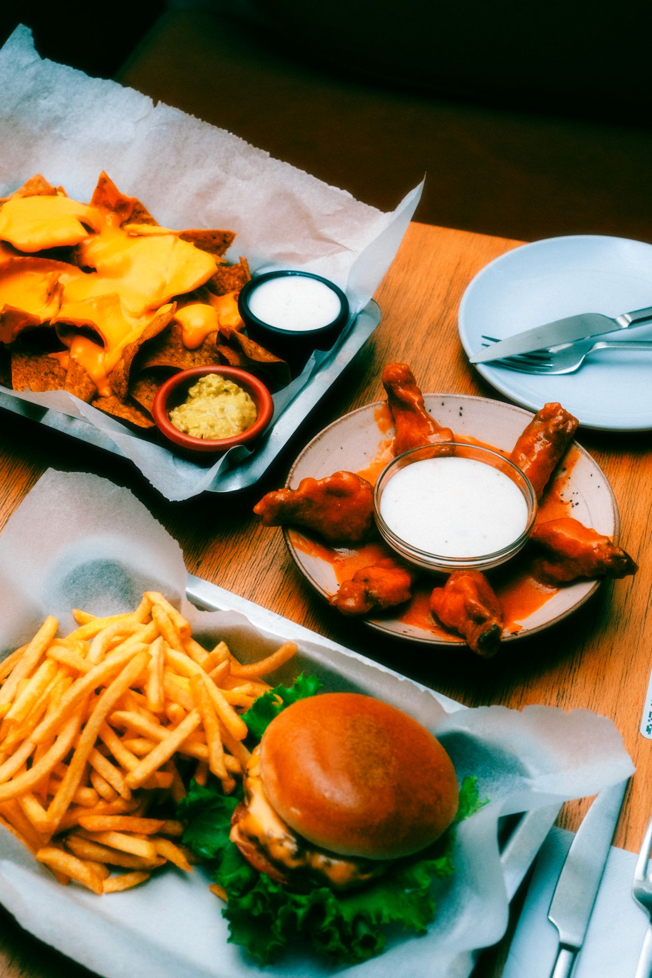 Tailgate food spread with nachos, dips, buffalo wings and fries