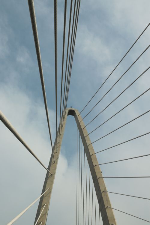 Free A stunning perspective shot of a modern suspension bridge against a bright sky. Stock Photo