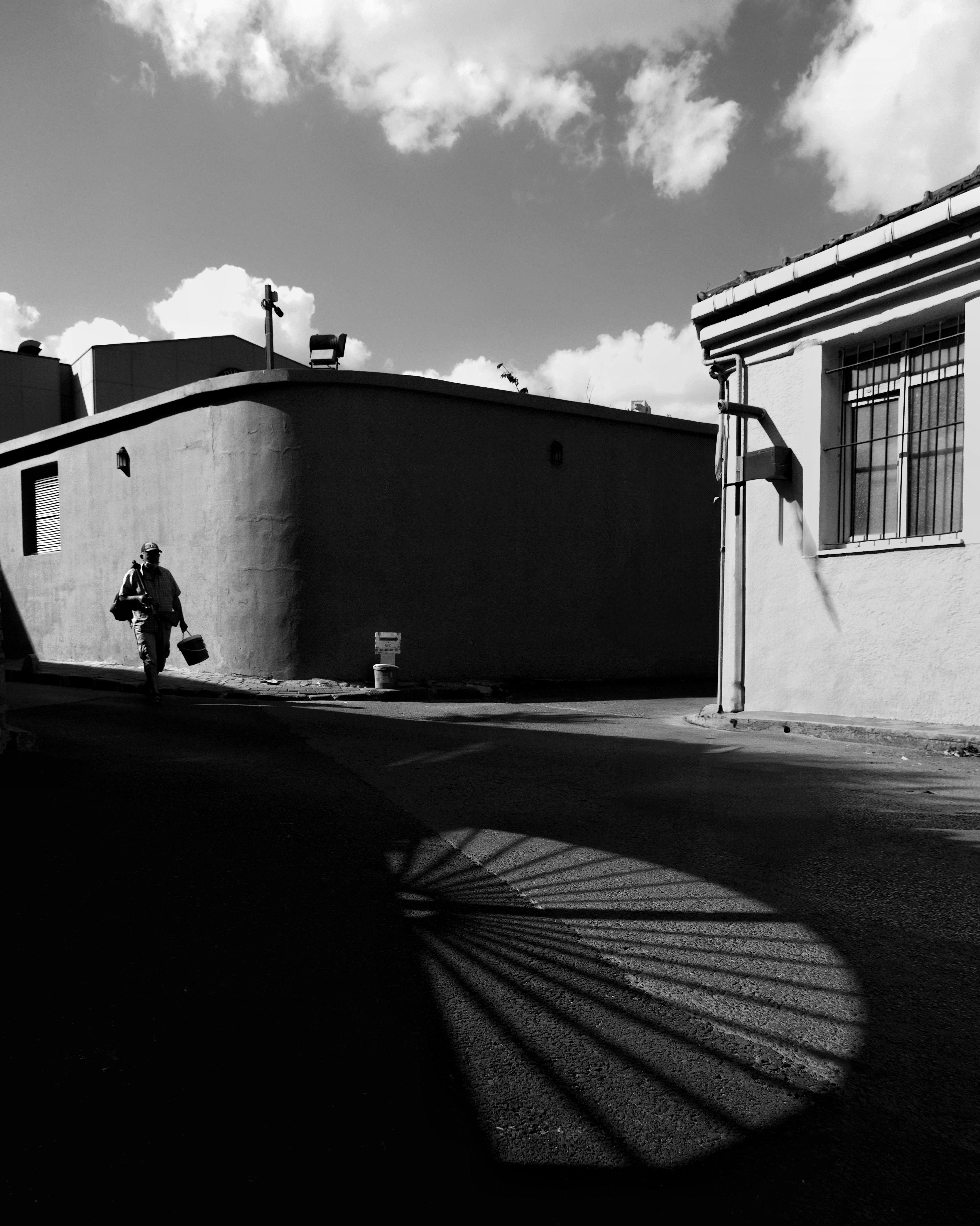 A black and white photo of a man walking down the street · Free Stock Photo