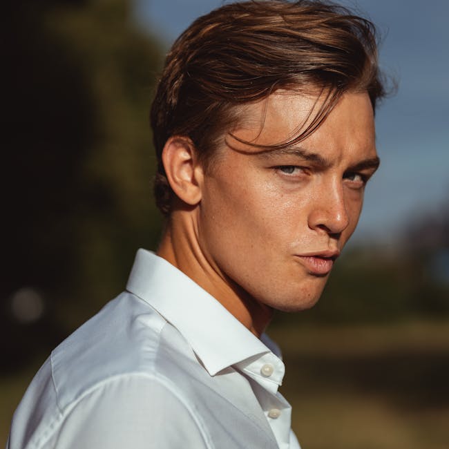 Portrait of a young man outdoors with sunlight creating strong shadows on his face.