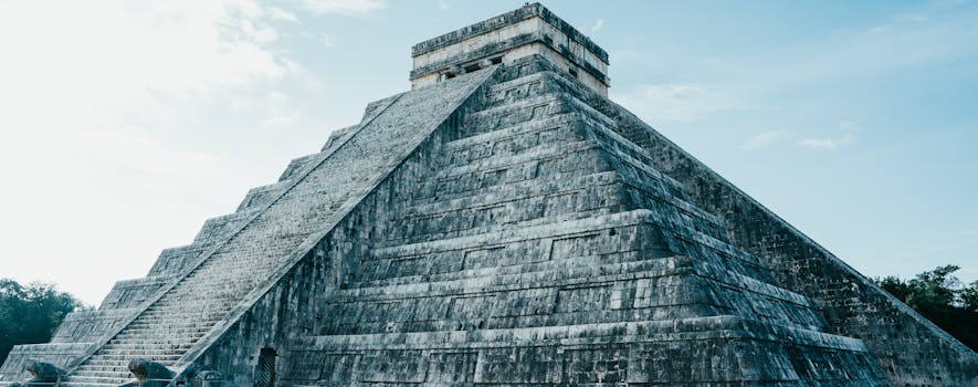 Majestic view of the ancient Mayan pyramid at Chichen Itza under a clear sky.