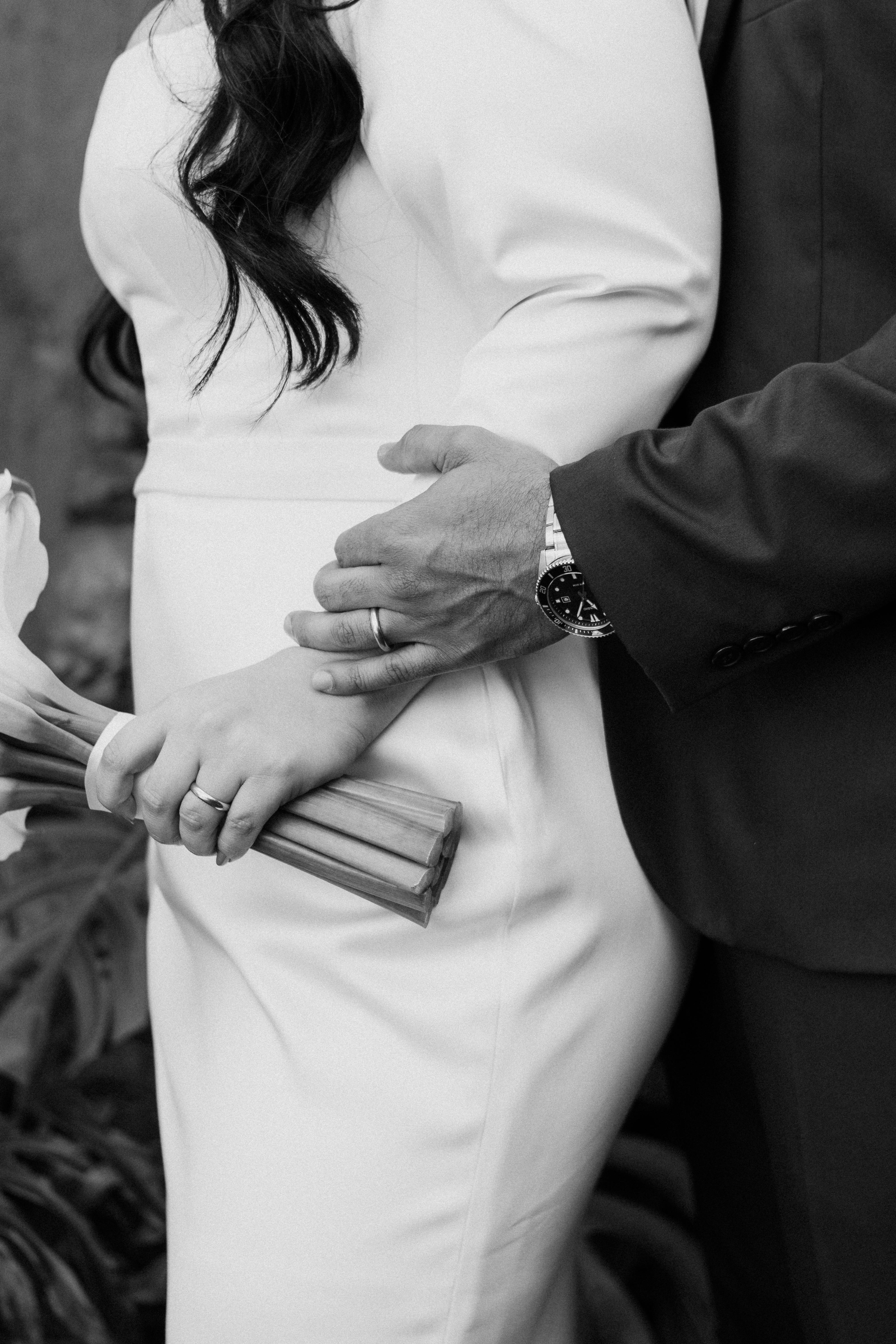 side view of a groom holding his wifes hips