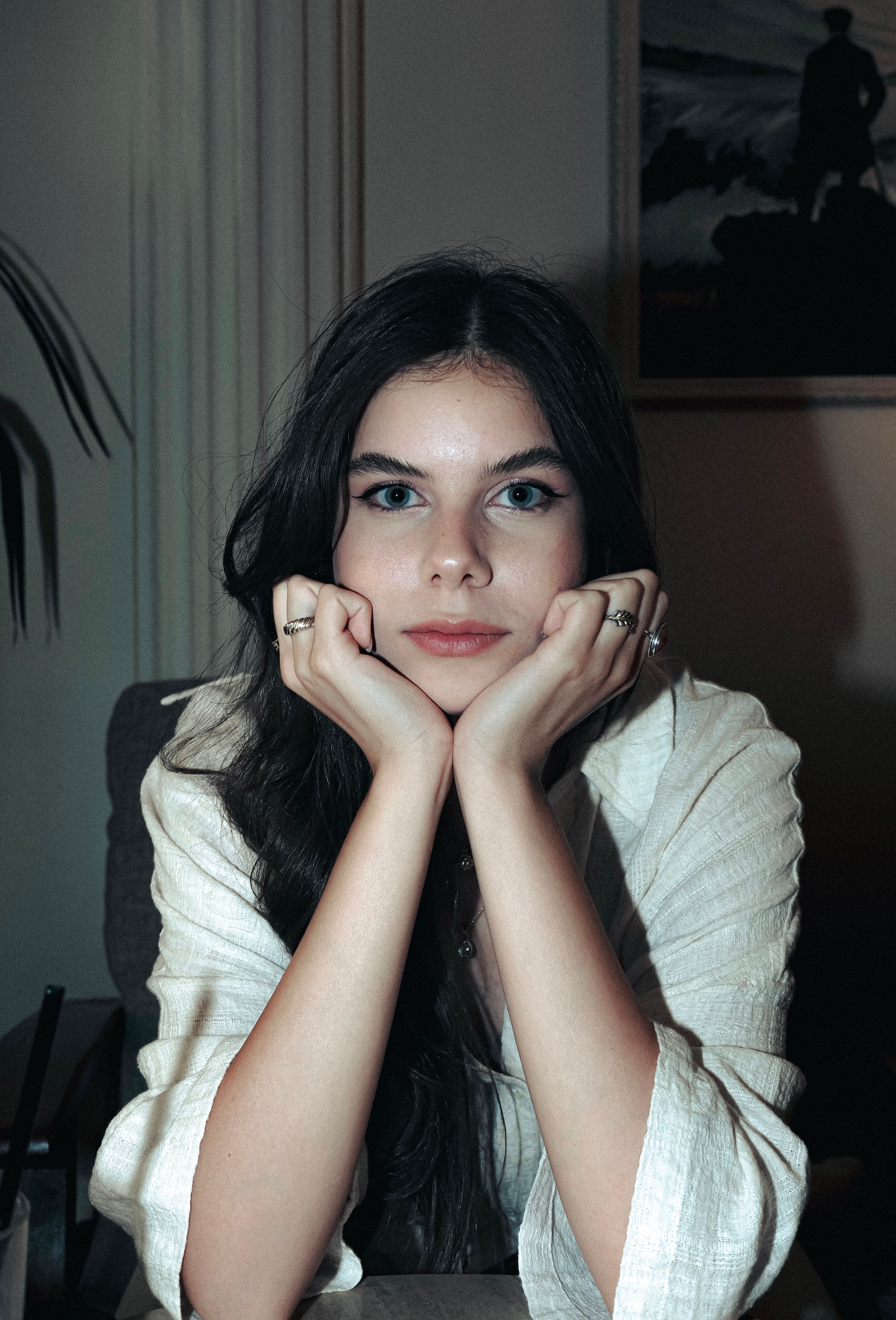 A woman sitting at a desk with her hands on her chin · Free Stock Photo