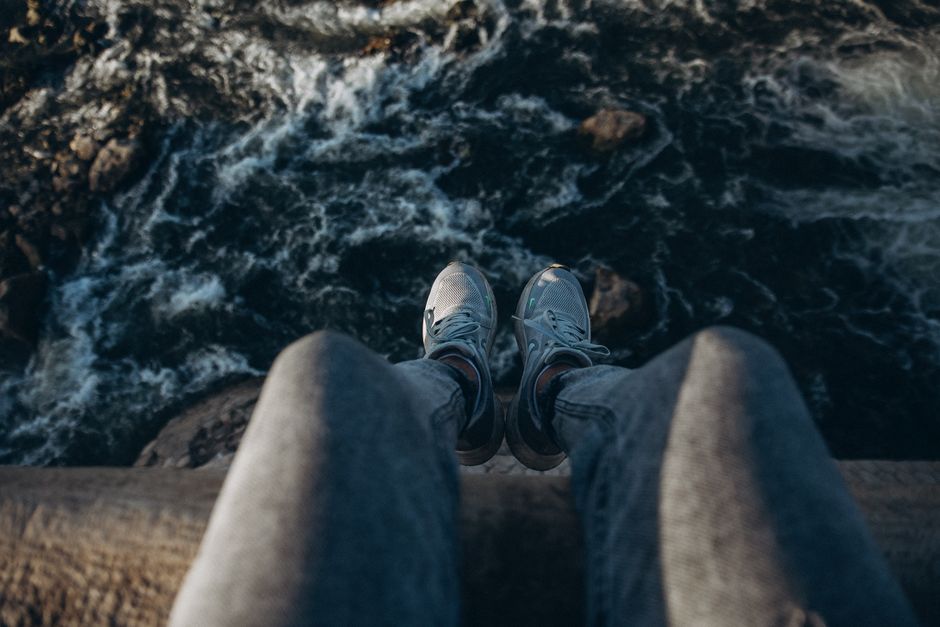 pexels photo 27899335 A person's legs dangling over a rushing river in Al Qanatir Al Khayriyyah, Egypt.