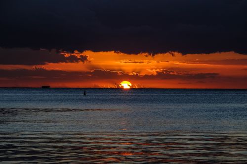 Free Breathtaking view of an orange sunset over the calm Indian Ocean waters. Stock Photo