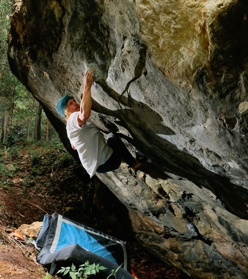 A climber working a bouldering problem