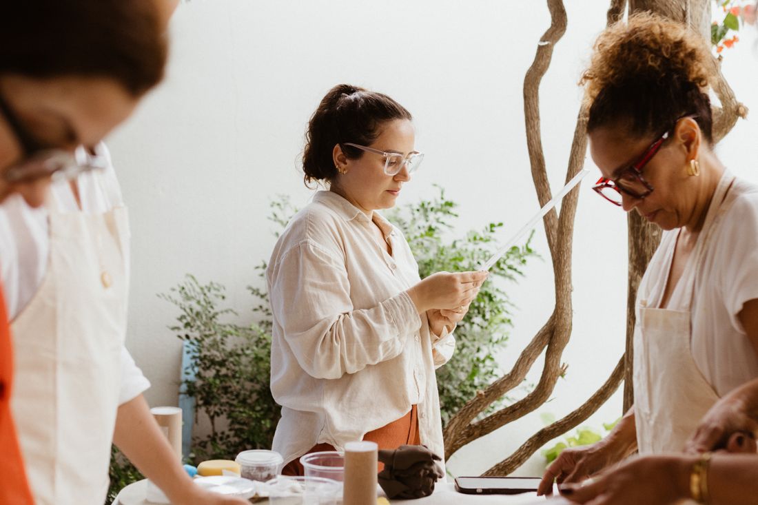 Three people shaping and glazing ceramics around a studio table — Jonathan Borba on Pexels
