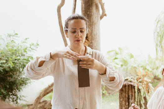 A woman is holding a book and looking at it