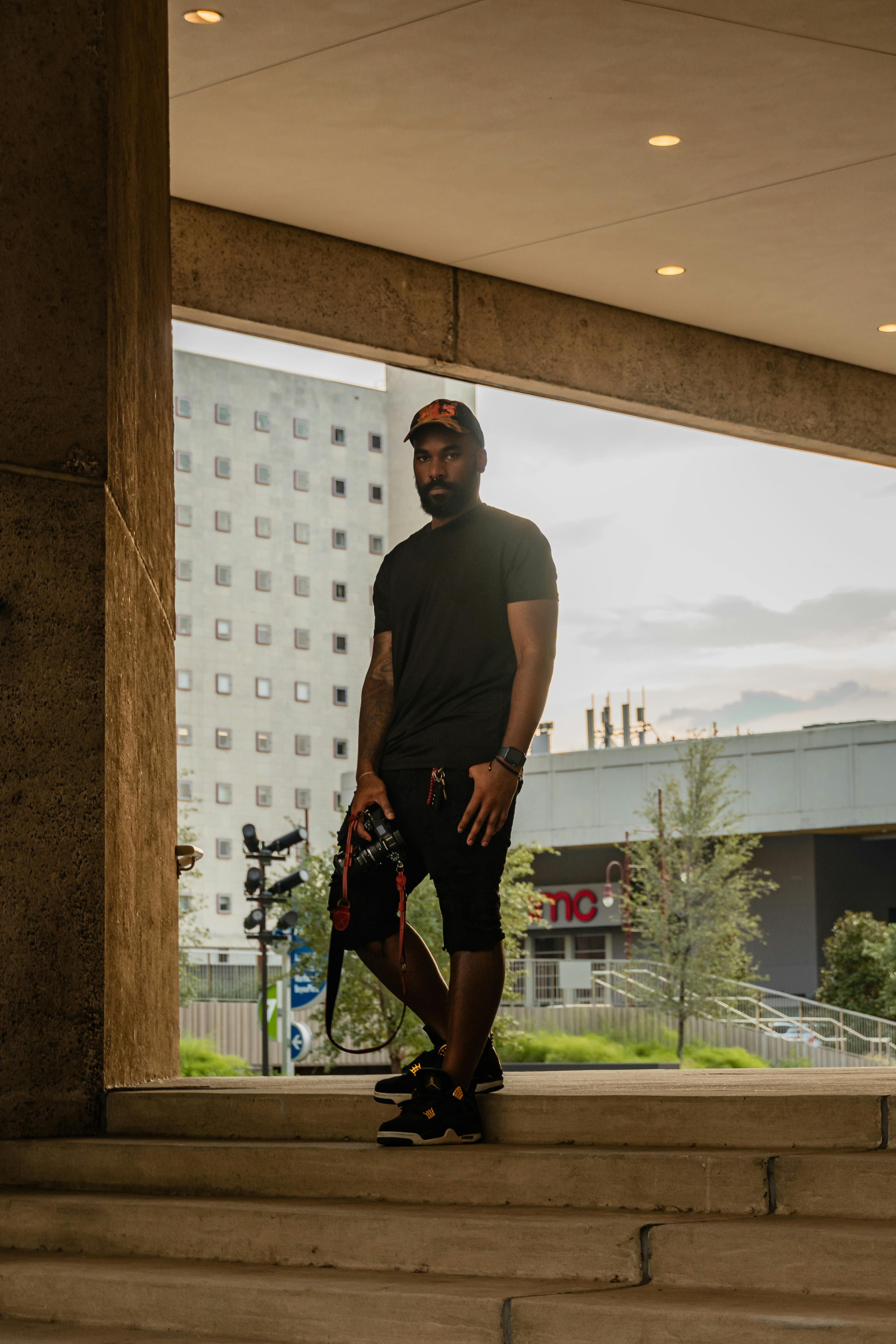 Dynamic portrait of a man standing in an urban setting in Houston, TX showcasing modern street style.