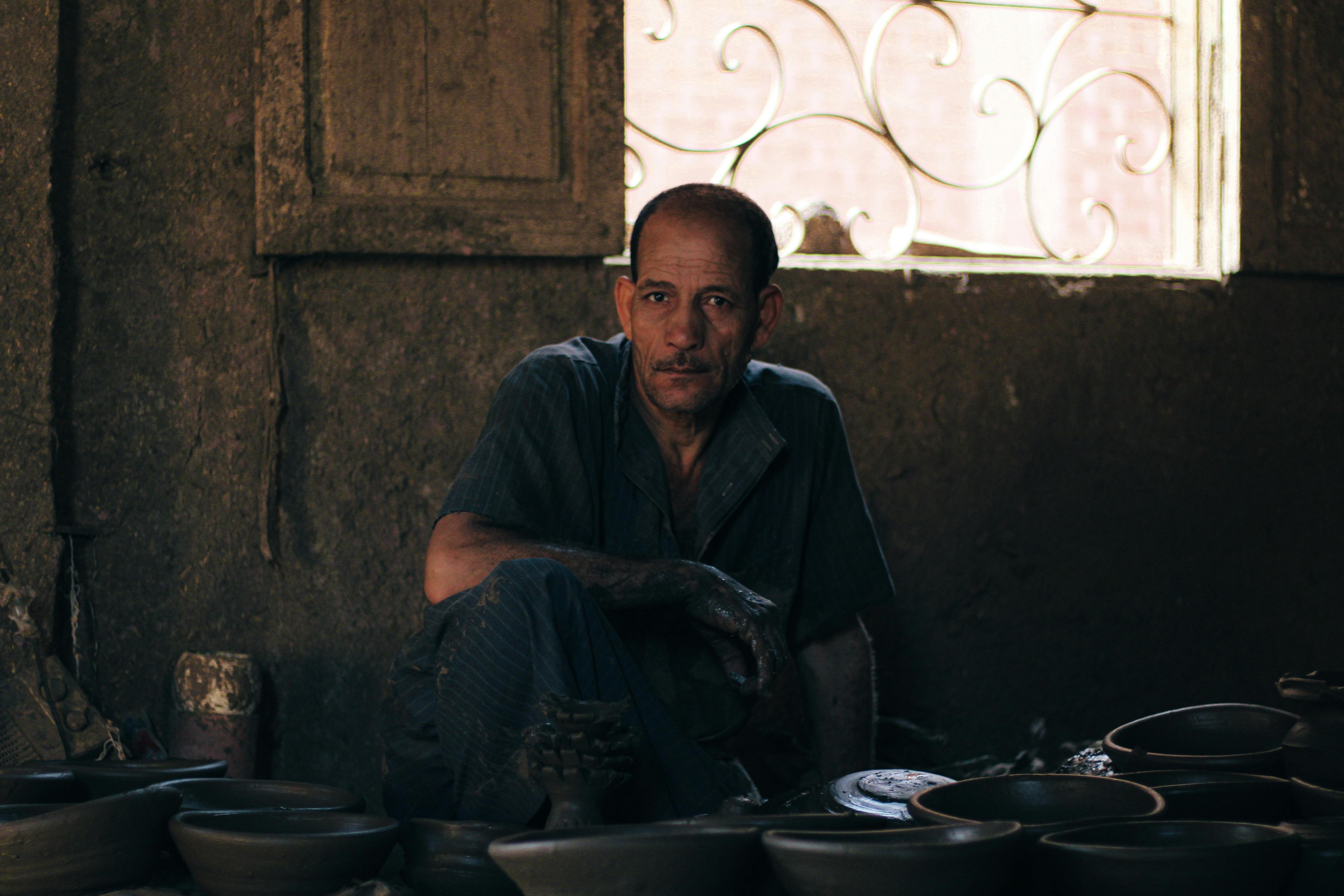 a man sitting in front of a bunch of pots