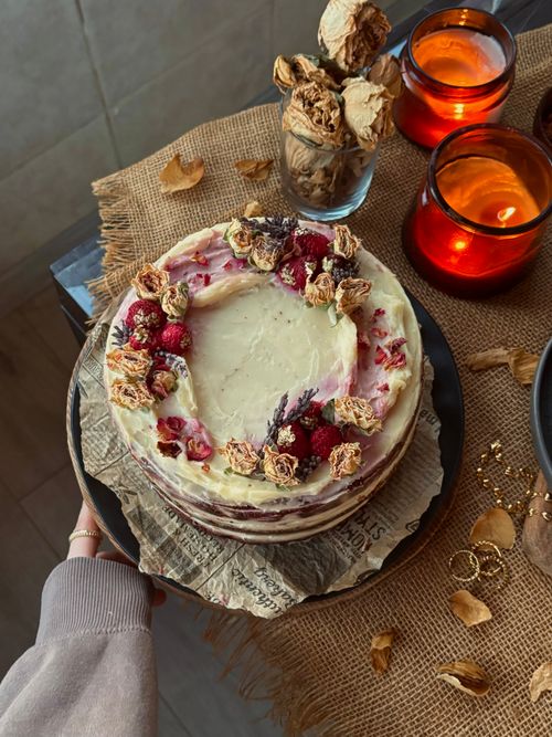 Free A beautifully decorated rustic cake with floral accents, surrounded by candles and dried flowers. Stock Photo