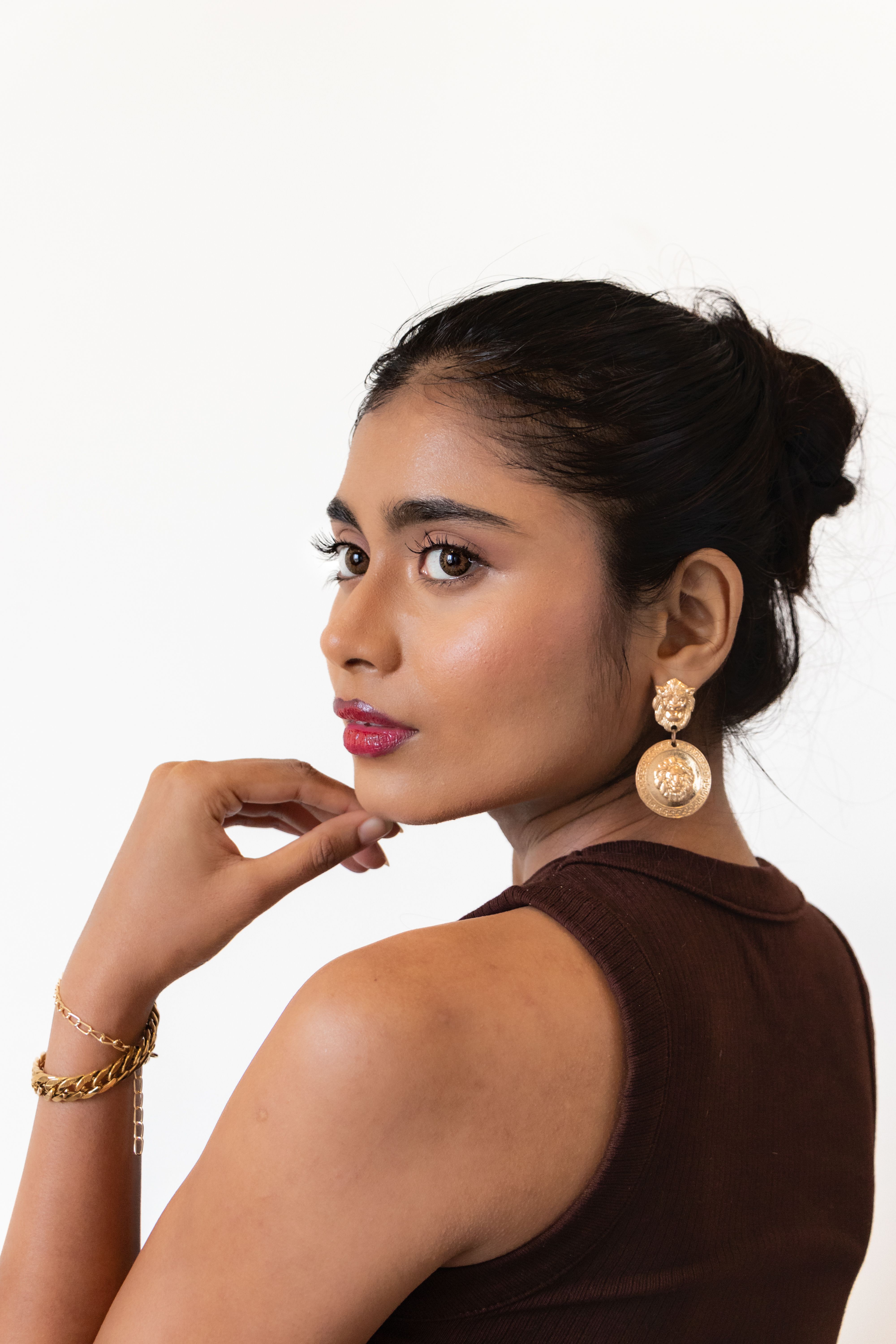 A woman in brown dress and gold earrings · Free Stock Photo