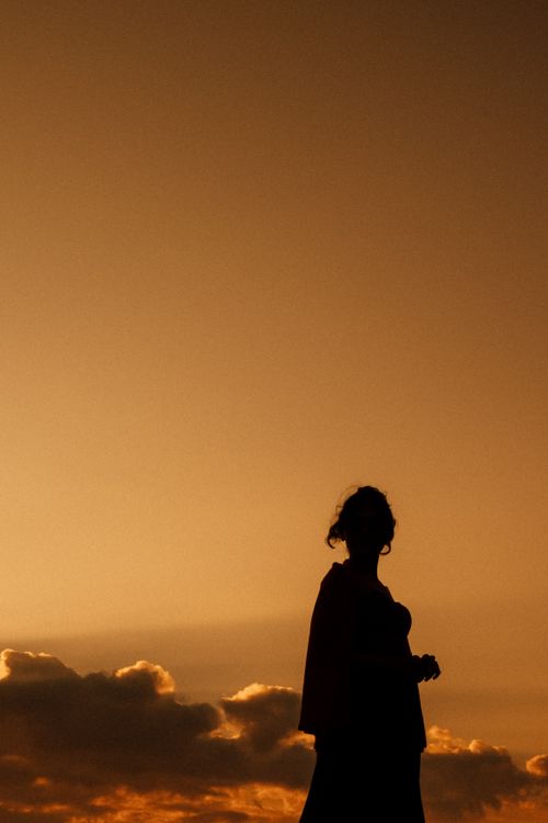 Free A captivating silhouette of a woman against a vibrant sunset sky in Chicago. Perfect for artistic projects. Stock Photo