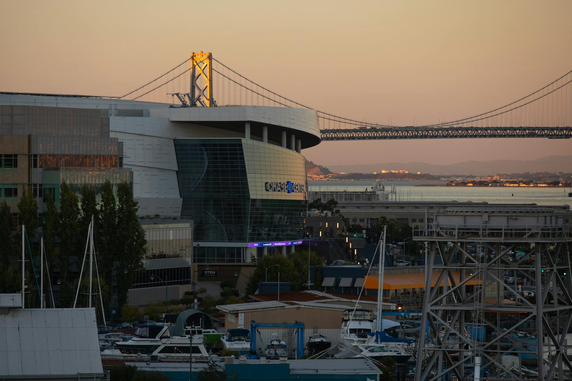 Stunning view of Chase Center and Bay Bridge during golden hour in San Francisco.