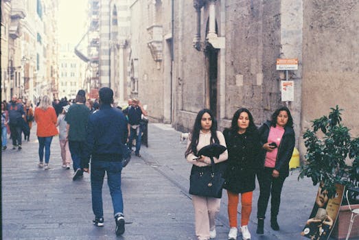 A vibrant daytime street scene with diverse pedestrians walking and interacting in an urban setting.