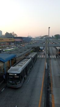 City buses on a busy roadway during early morning commute, showcasing urban transportation.
