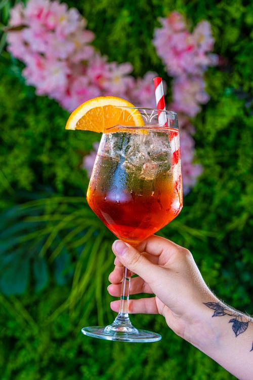 Free Vibrant summer cocktail with orange slice and straw, perfect for celebrations. Stock Photo