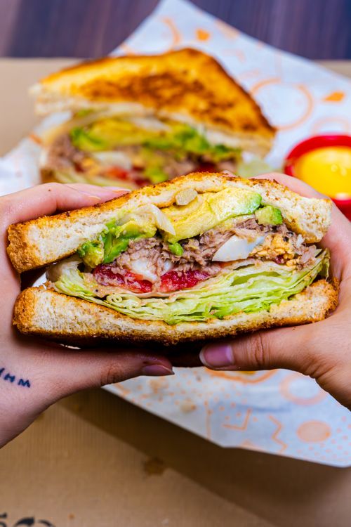 Free Close-up of a fresh sandwich with lettuce, tomato, and avocado, perfect for lunch. Stock Photo