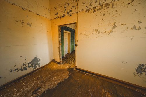 Free A decaying indoor room with peeling walls and an open doorway. Perfect for urban exploration themes. Stock Photo