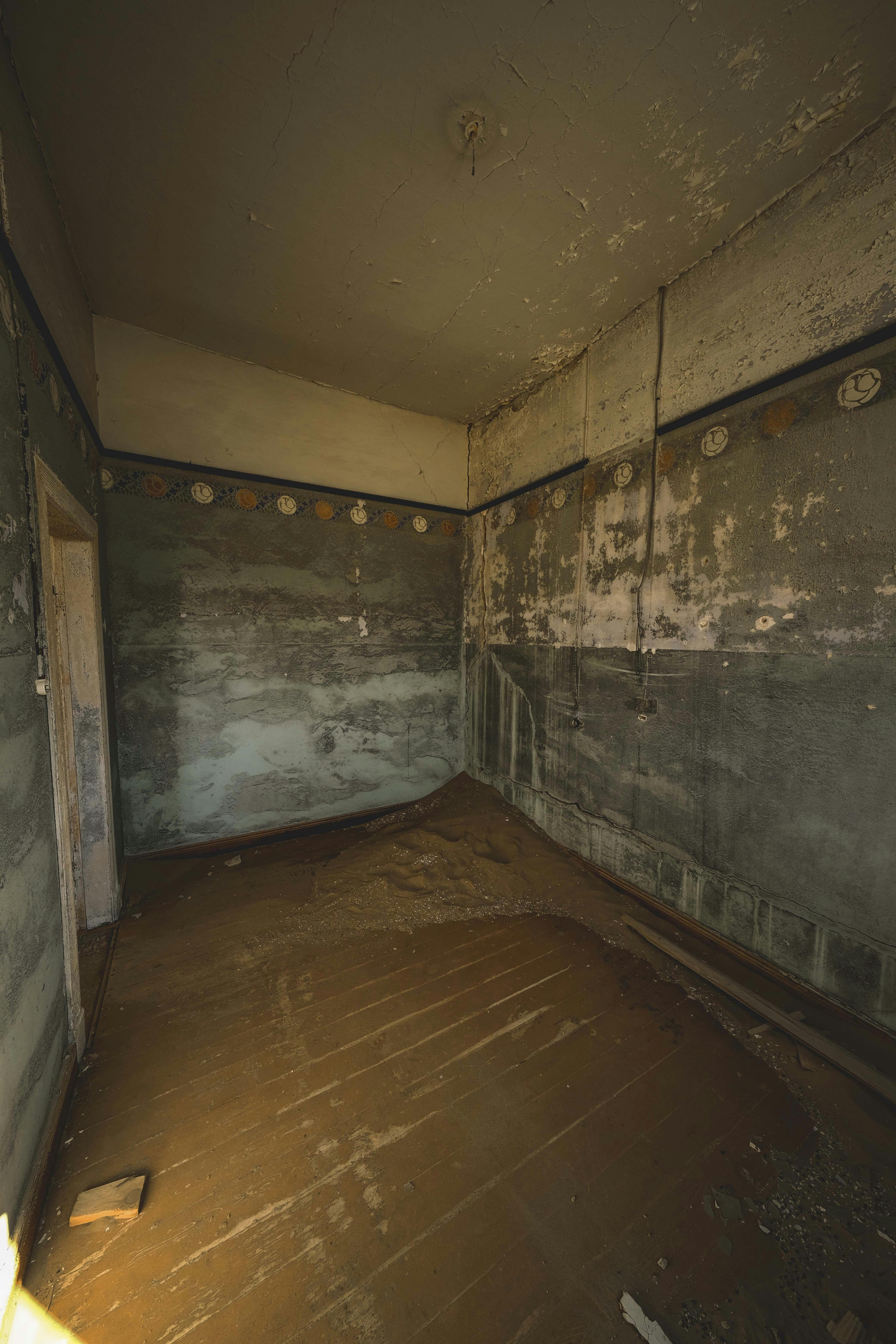 Explore a derelict room with peeling paint, dust, and decay hinting at a forgotten past.