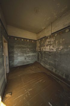 Explore a derelict room with peeling paint, dust, and decay hinting at a forgotten past.