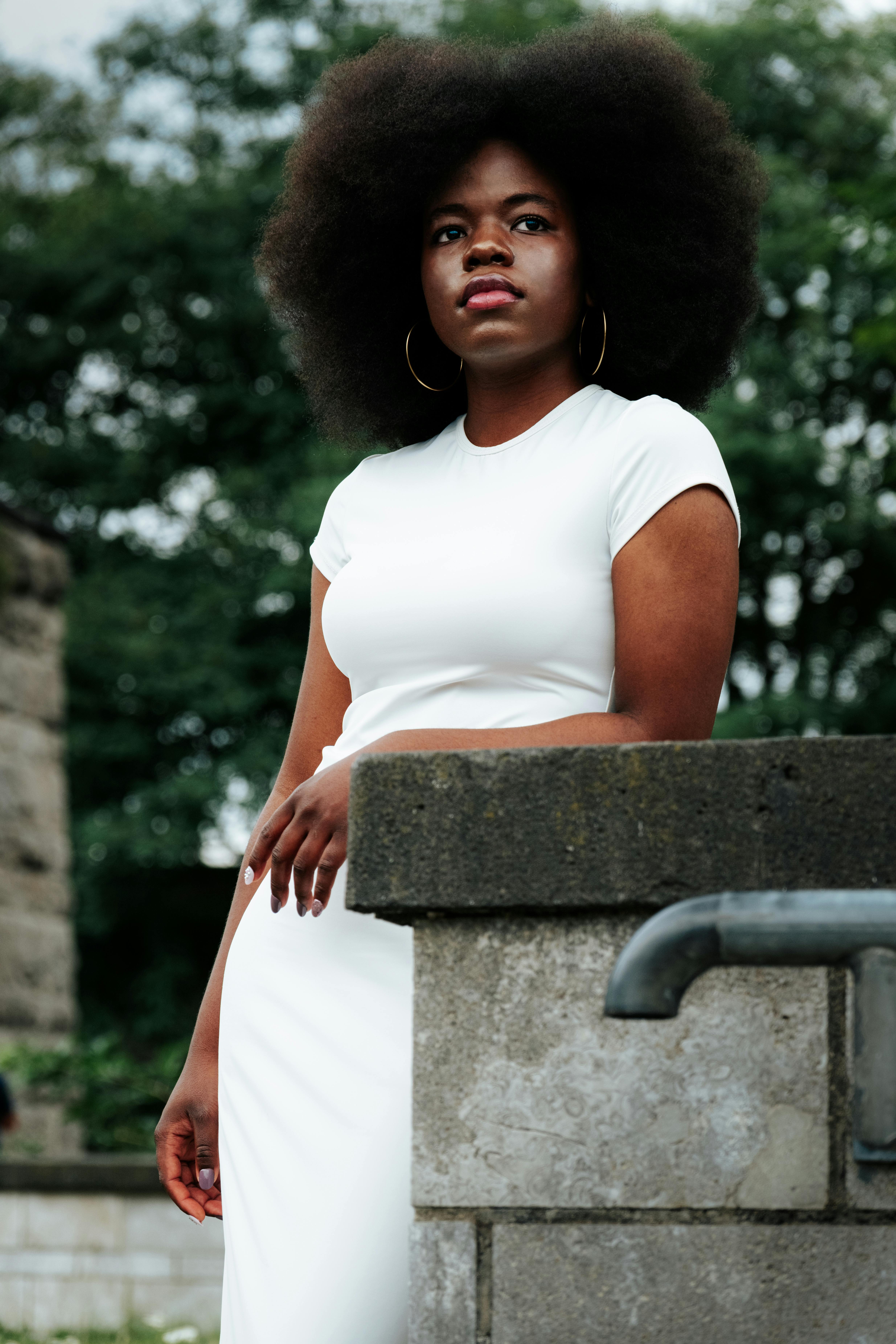 african woman learning against a wall