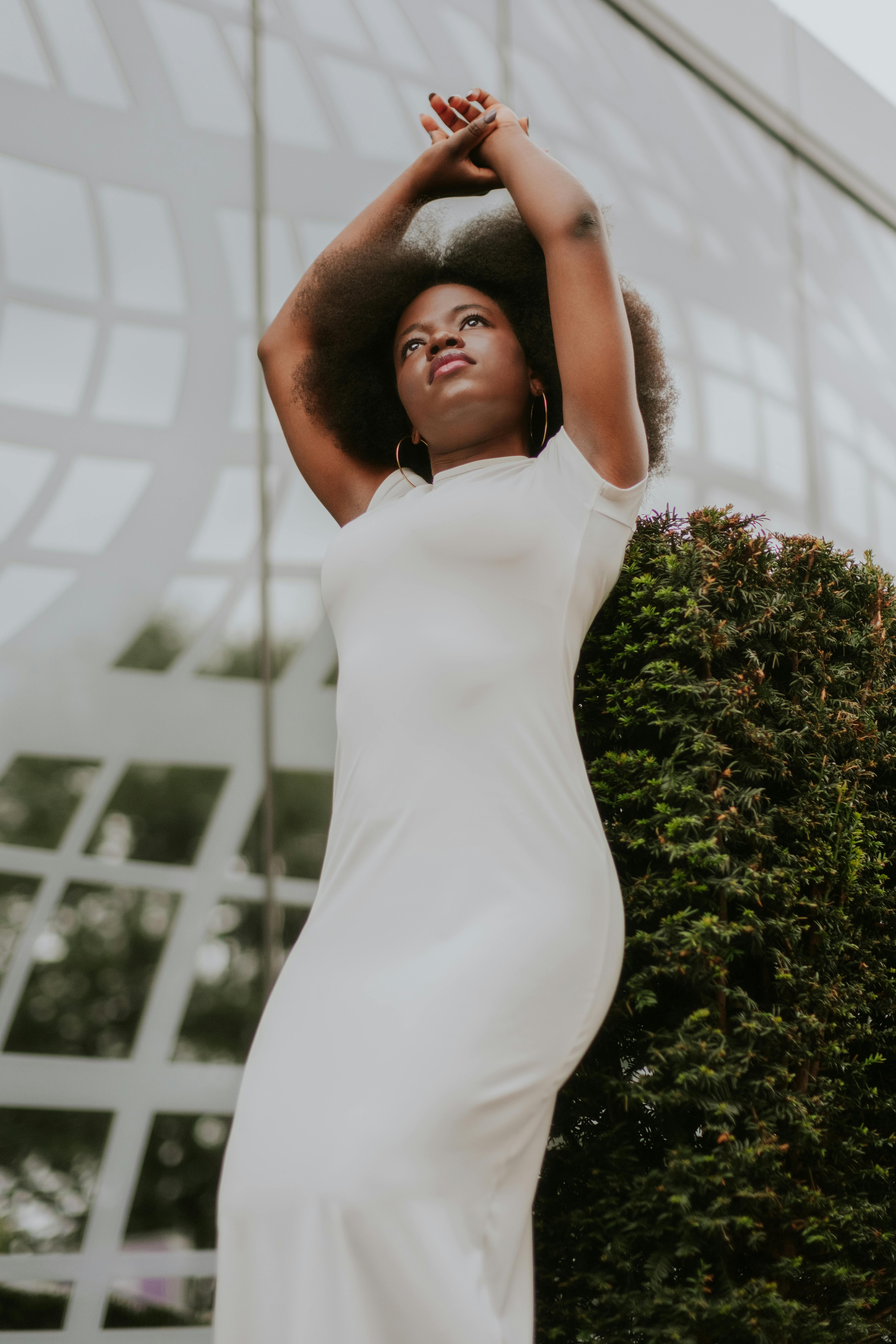 woman leaning against a bush