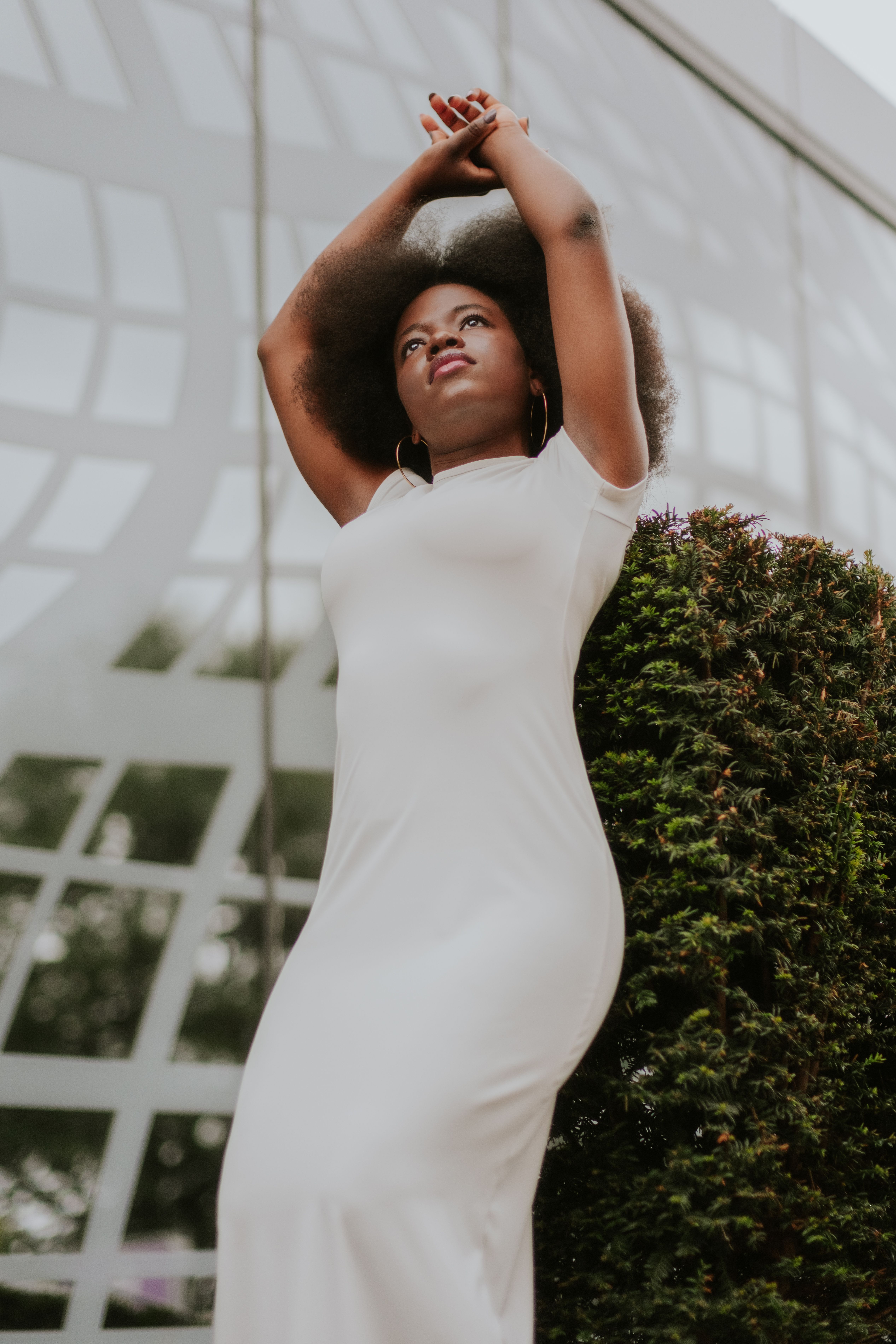 woman leaning against a bush · Free Stock Photo
