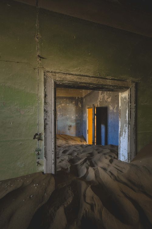 Free Explore an abandoned building overtaken by desert sand, creating a surreal indoor landscape. Stock Photo
